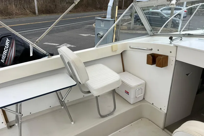 Slide: The Image of 1970 Bertram 25 Moppie boat interior with seating, cooler, and Mercury engine. - 26