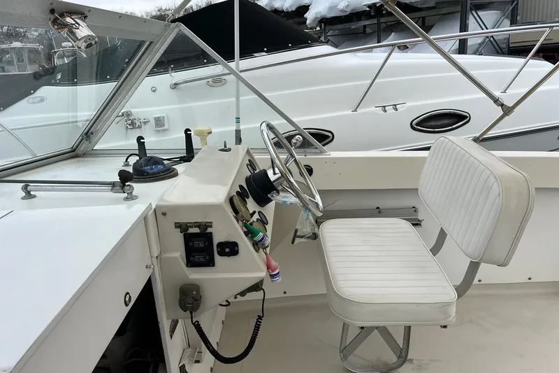 Slide: The Image of 1970 Bertram 25 Moppie boat interior with steering wheel and white seating. - 27