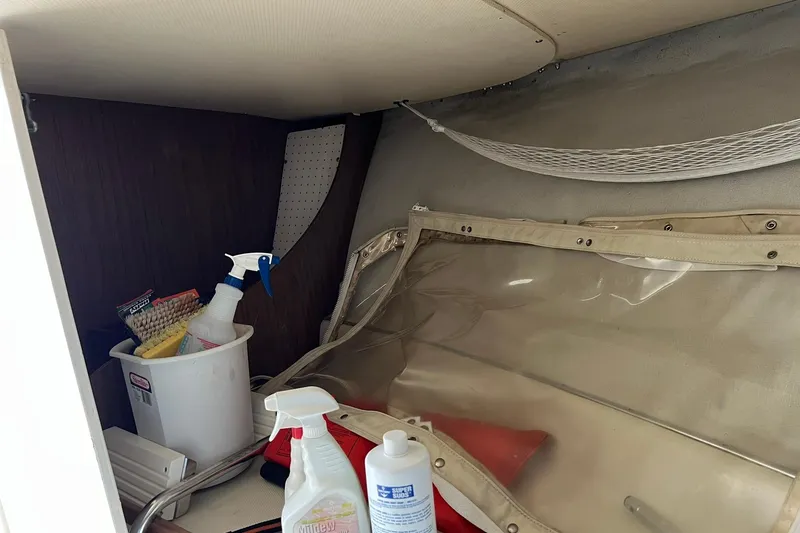 Slide: The Image of Storage area inside a 1970 Bertram 25 Moppie boat with cleaning supplies. - 32