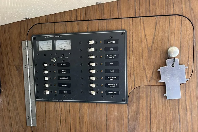 Slide: The Image of 1970 Bertram 25 Moppie electrical panel with switches and gauges on wooden background. - 33