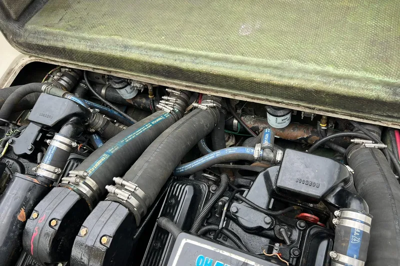 Slide: The Image of Engine compartment of a 1970 Bertram 25 Moppie boat, showcasing hoses and components. - 42