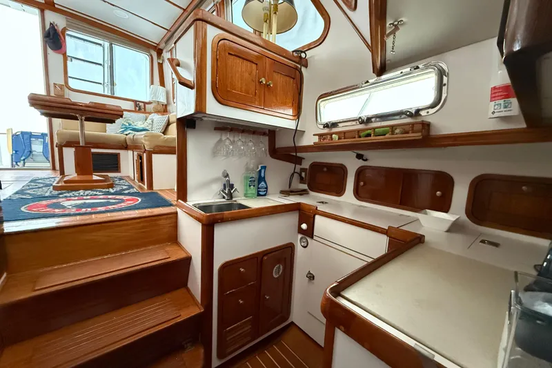 Slide: The Image of Interior of 1996 Legacy Yachts 40, featuring a cozy kitchen and seating area. - 13