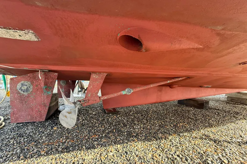 Slide: The Image of Bottom view of 1996 Legacy Yachts 40, showcasing propeller and rudder on gravel. - 32