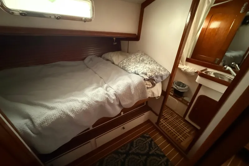 Slide: The Image of Cozy cabin interior of 1996 Legacy Yachts 40, featuring a comfortable bed and compact bathroom. - 16