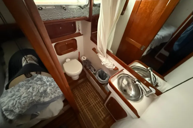 Slide: The Image of Interior of 1996 Legacy Yachts 40, featuring a compact bathroom with sink and toilet. - 17