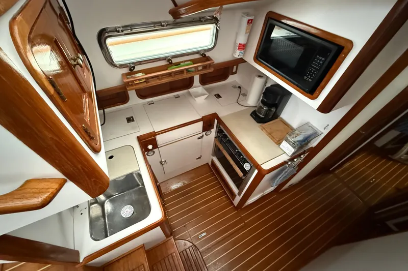 Slide: The Image of Legacy Yachts 1996 model 40 interior kitchen with wooden cabinetry and modern appliances. - 11
