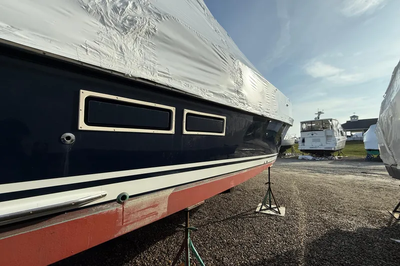 Slide: The Image of 1996 Legacy Yachts 40 in dry dock, partially covered, with other boats nearby. - 29