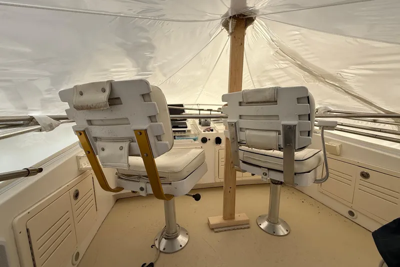 Slide: The Image of Interior of 1996 Legacy Yachts 40 with two white captain chairs under a protective cover. - 28