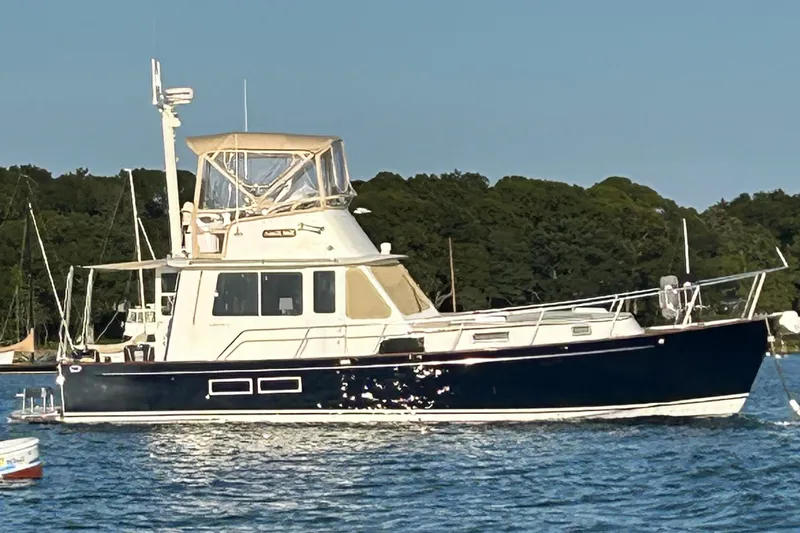 The Image of 1996 Legacy Yachts 40 on water, featuring classic design and elegant navy hull. - 1