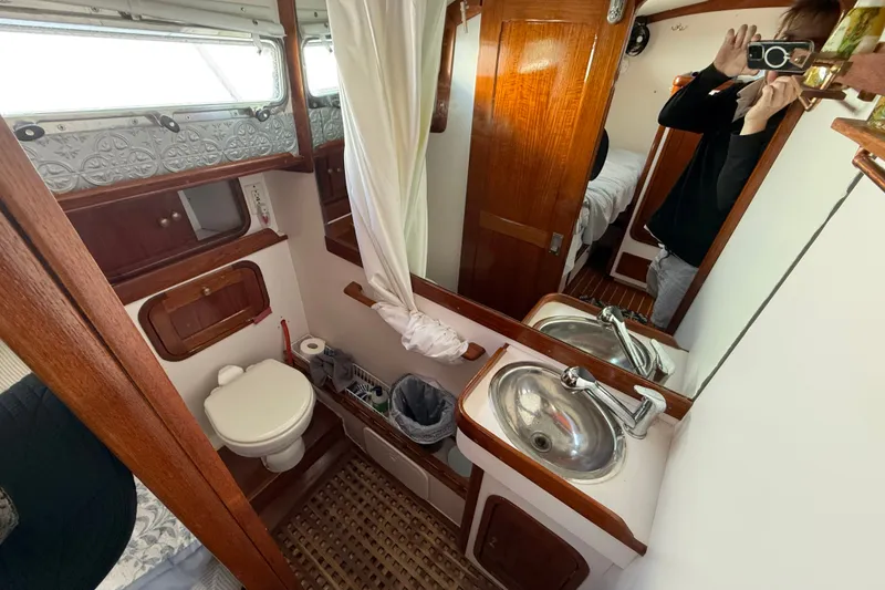 Slide: The Image of 1996 Legacy Yachts 40 bathroom with sink, toilet, and wooden cabinetry. - 28