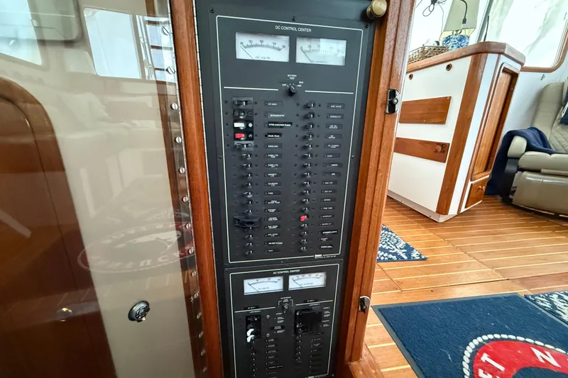 Slide: The Image of Electrical control panel inside 1996 Legacy Yachts 40, featuring wood accents and nautical decor. - 15