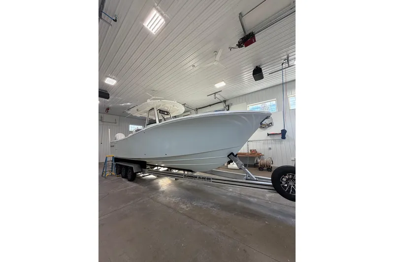 Slide: The Image of 2023 Regulator 31 boat on trailer in a well-lit garage. - 1