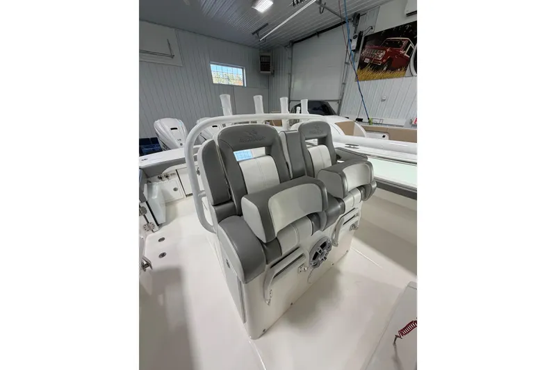 Slide: The Image of 2023 Regulator 31 boat interior with cushioned seating in a well-lit garage. - 11