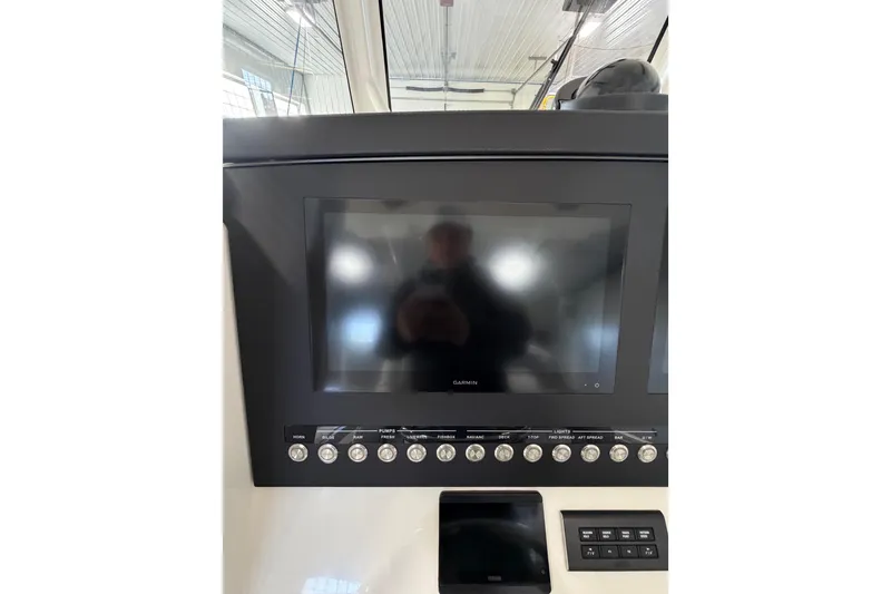 Slide: The Image of 2023 Regulator 31 boat dashboard with Garmin display and control panel. - 13