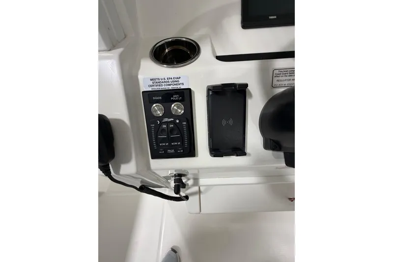 Slide: The Image of Control panel of 2023 Regulator 31 boat with switches and phone holder. - 16