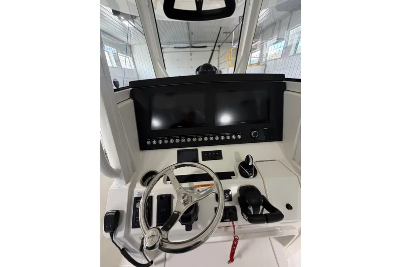 Slide: The Image of 2023 Regulator 31 boat helm with dual screens and modern controls in a bright interior. - 18