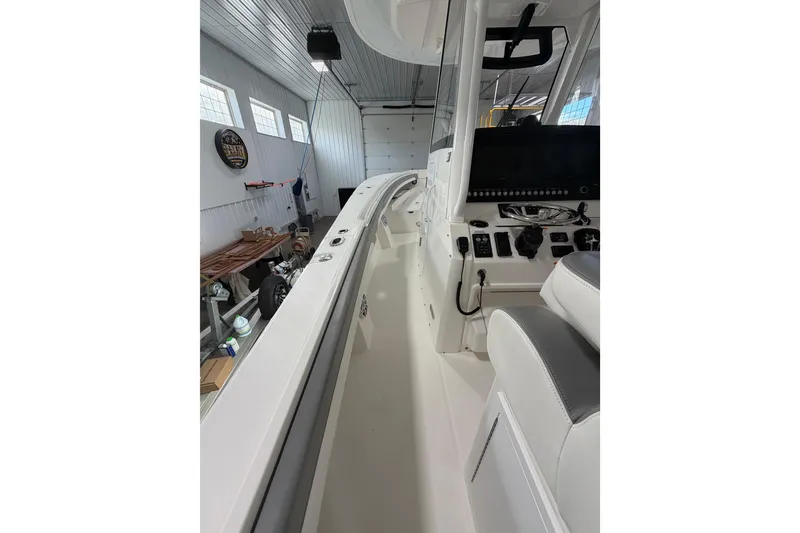 Slide: The Image of 2023 Regulator 31 boat interior in a garage, showcasing helm and seating area. - 19