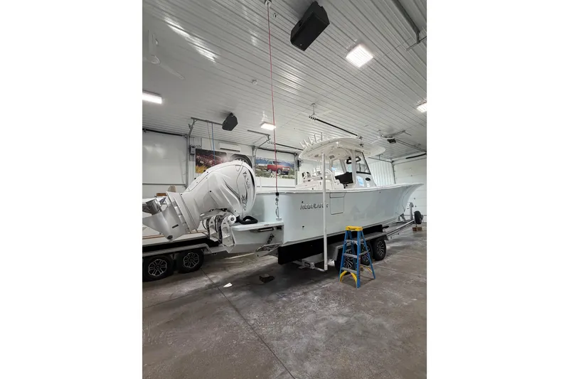 Slide: The Image of 2023 Regulator 31 boat in a garage, featuring dual outboard motors. - 2