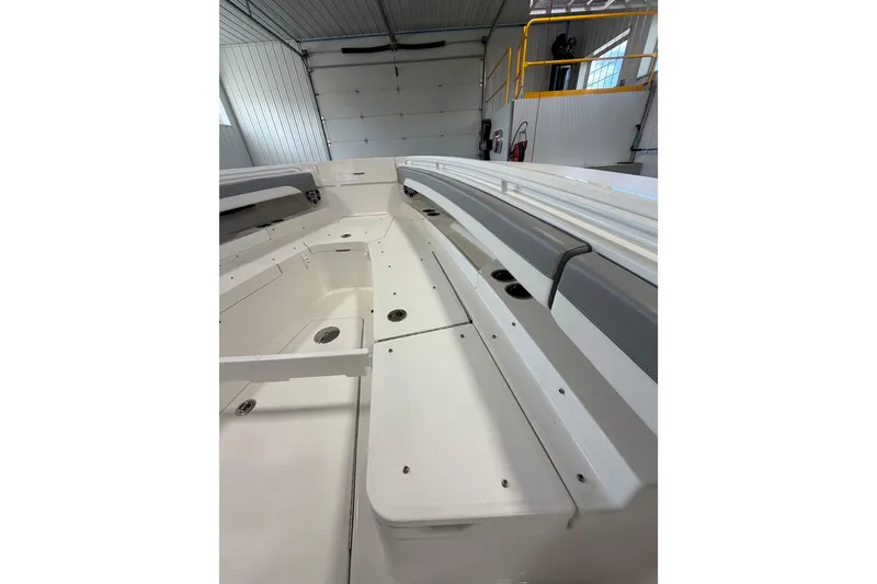Slide: The Image of 2023 Regulator 31 boat interior, showcasing spacious seating and sleek design in a garage setting. - 27