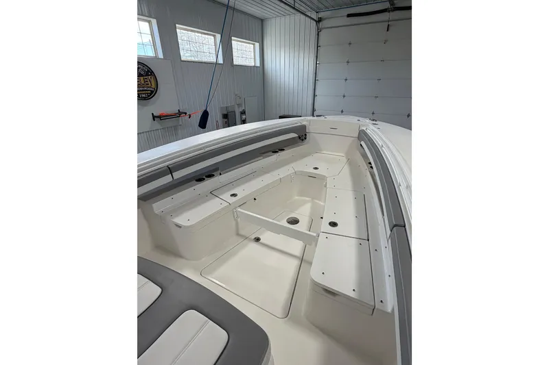 Slide: The Image of 2023 Regulator 31 boat interior with spacious seating and storage in a garage setting. - 28