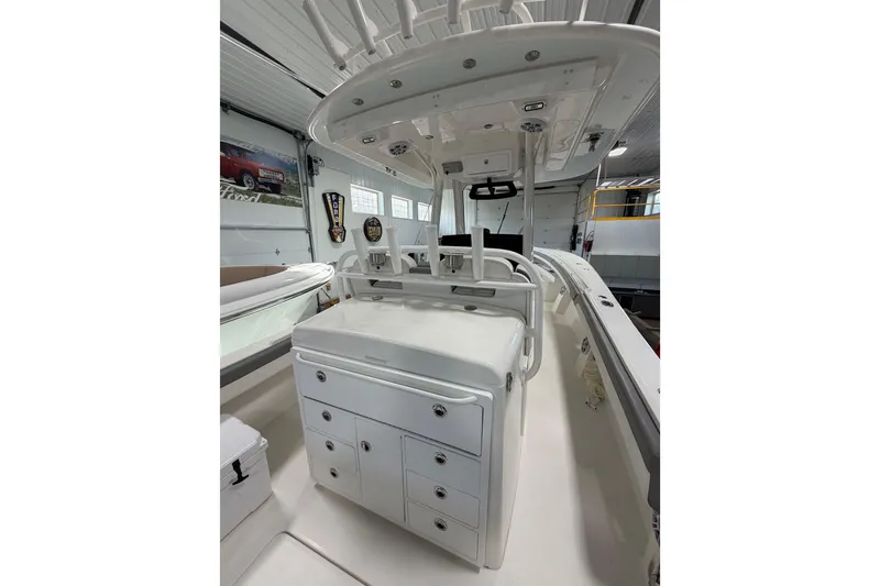 Slide: The Image of 2023 Regulator 31 boat interior with storage compartments and rod holders in a garage setting. - 5