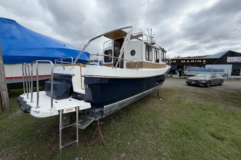 Slide: The Image of 2014 Ranger Tugs R-27 boat on display at marina, overcast sky. - 10