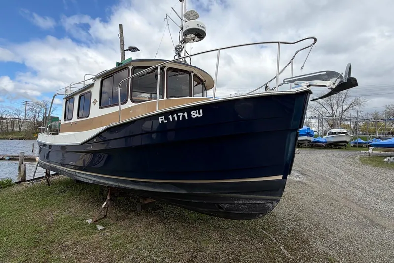 Slide: The Image of 2014 Ranger Tugs R-27 boat on land, blue hull, dockside view. - 12