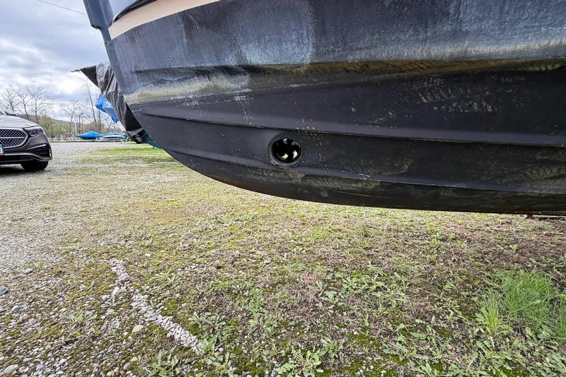 Slide: The Image of 2014 Ranger Tugs R-27 boat hull on stands, grassy ground, side view. - 14