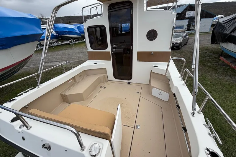 Slide: The Image of 2014 Ranger Tugs R-27 boat deck with cushioned seating and water view. - 16
