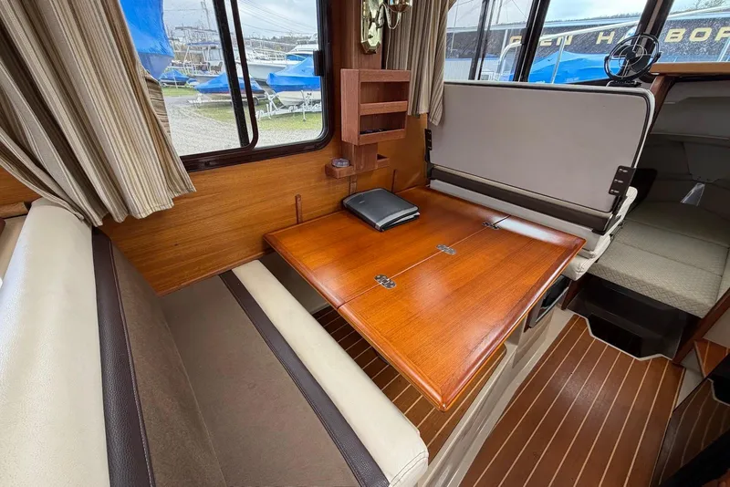 Slide: The Image of Interior of a 2014 Ranger Tugs R-27 boat with helm and seating area. - 21