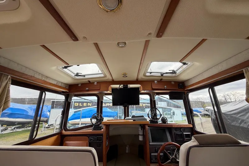 Slide: The Image of Interior of 2014 Ranger Tugs R-27 with wooden table and seating area. - 29