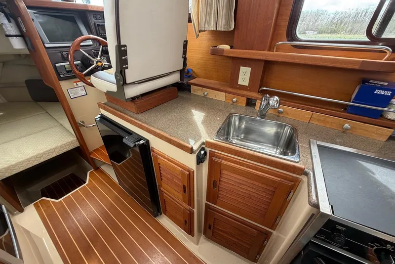 Slide: The Image of Interior of 2014 Ranger Tugs R-27 boat with helm, seating, and kitchenette. - 33