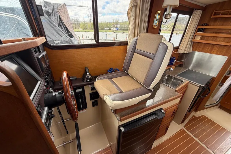 Slide: The Image of 2014 Ranger Tugs R-27 helm with steering wheel, controls, and navigation equipment. - 34