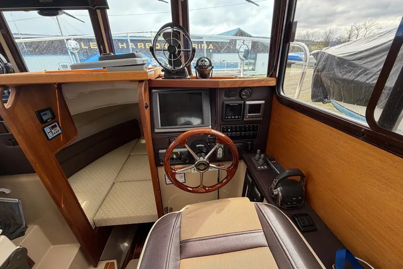 Slide: The Image of 2014 Ranger Tugs R-27 helm with controls, steering wheel, and dashboard instruments. - 35