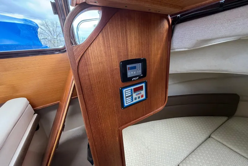 Slide: The Image of 2014 Ranger Tugs R-27 cabin interior with cushioned berth and control panel. - 37