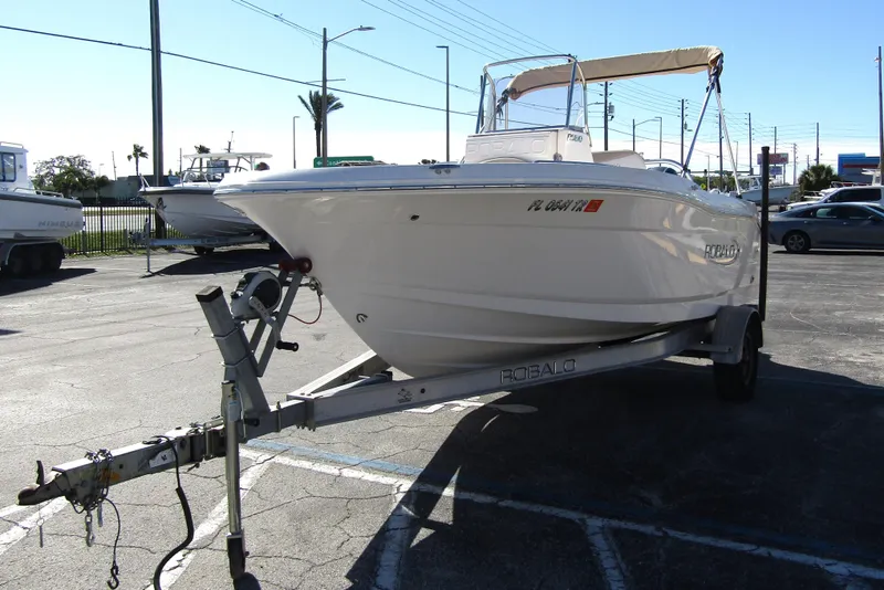 Slide: The Image of 2019 Robalo R180 Center Console boat on trailer in parking lot. - 2
