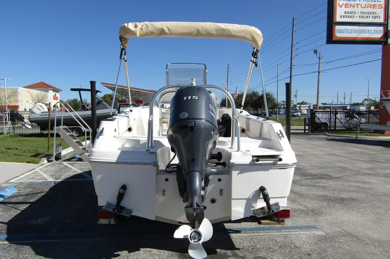 Slide: The Image of 2019 Robalo R180 Center Console boat with outboard motor, parked outdoors. - 5