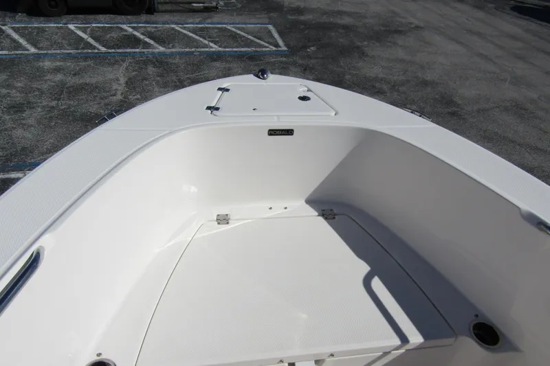 Slide: The Image of 2019 Robalo R180 Center Console boat bow area, white interior, docked on asphalt. - 7