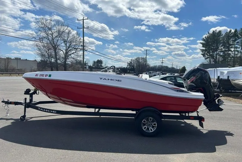The Image of 2025 Tahoe T18 boat on trailer, red and white design, parked outdoors under blue sky. - 1