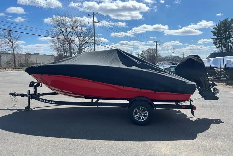 Slide: The Image of 2025 Tahoe T18 boat with cover on trailer under a clear blue sky. - 14