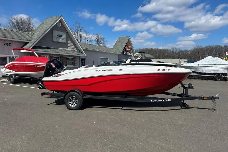 Slide: The Image of 2025 Tahoe T18 boat in red and white on a trailer, parked outside a dealership. - 4