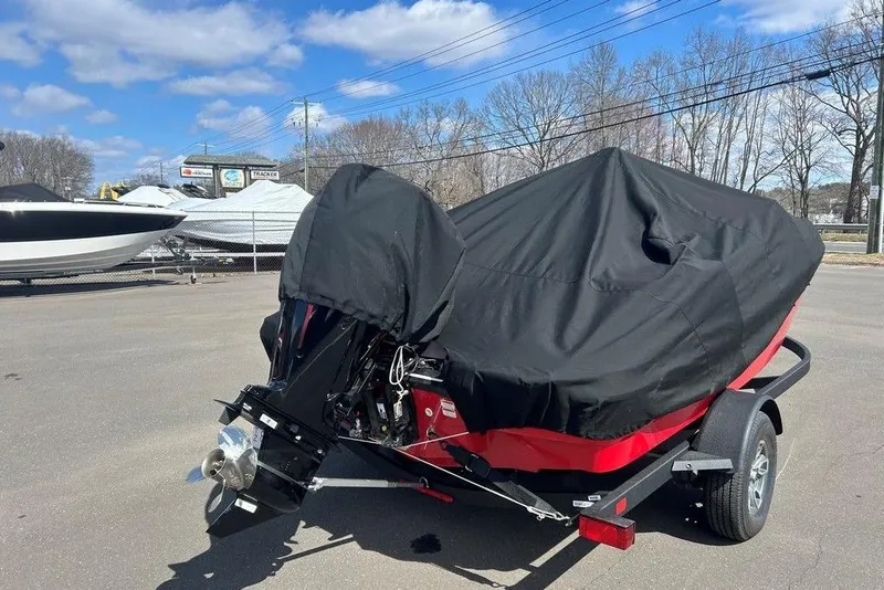 Slide: The Image of 2025 Tahoe T18 boat covered on trailer, parked outdoors under a clear sky. - 5