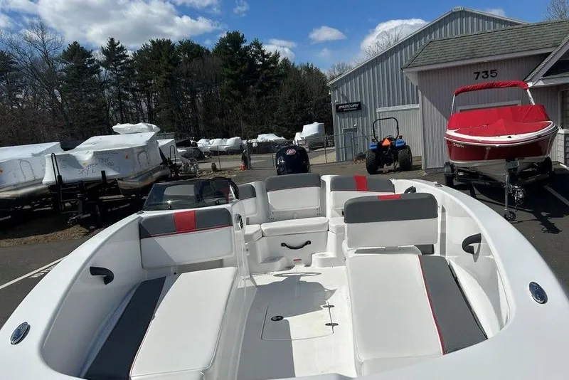 Slide: The Image of 2025 Tahoe T18 boat interior with seating, parked outdoors under a blue sky. - 8