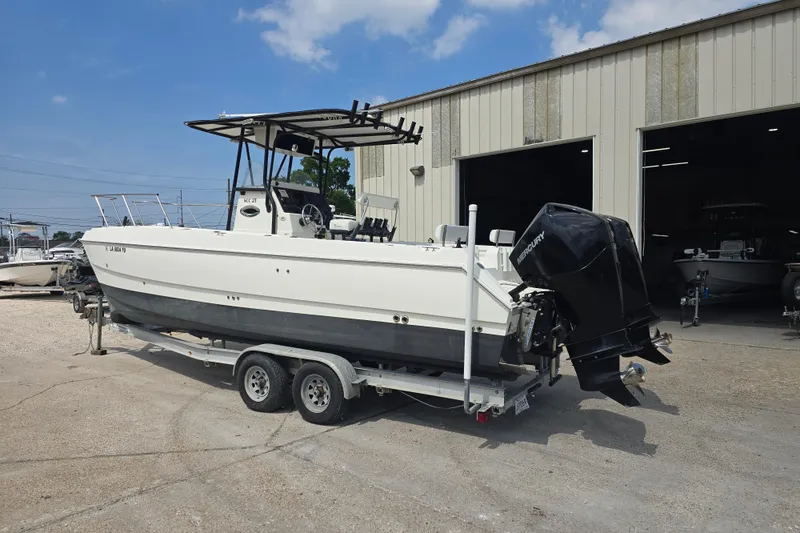 Slide: The Image of 2002 Sport-Craft Seacat 255 boat on trailer outside a garage. - 1