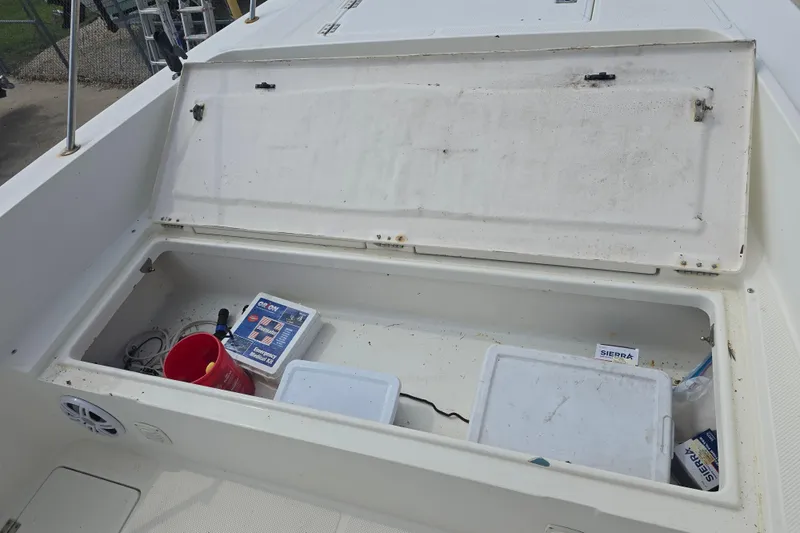 Slide: The Image of Open storage compartment on 2002 Sport-Craft Seacat 255 boat with various items inside. - 17