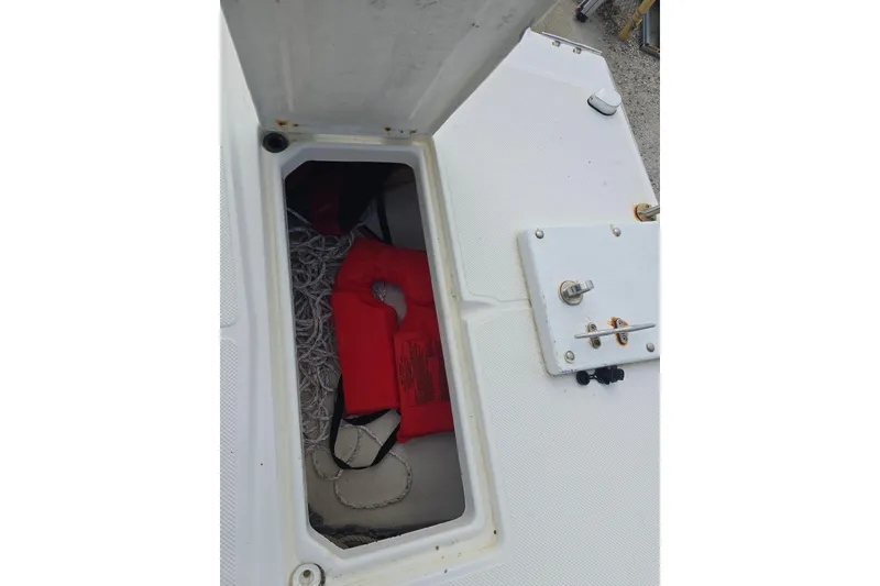 Slide: The Image of Open storage compartment on 2002 Sport-Craft Seacat 255 boat with life jacket and rope. - 19