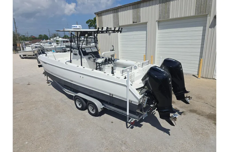 Slide: The Image of 2002 Sport-Craft Seacat 255 boat with dual outboard motors on a trailer. - 23