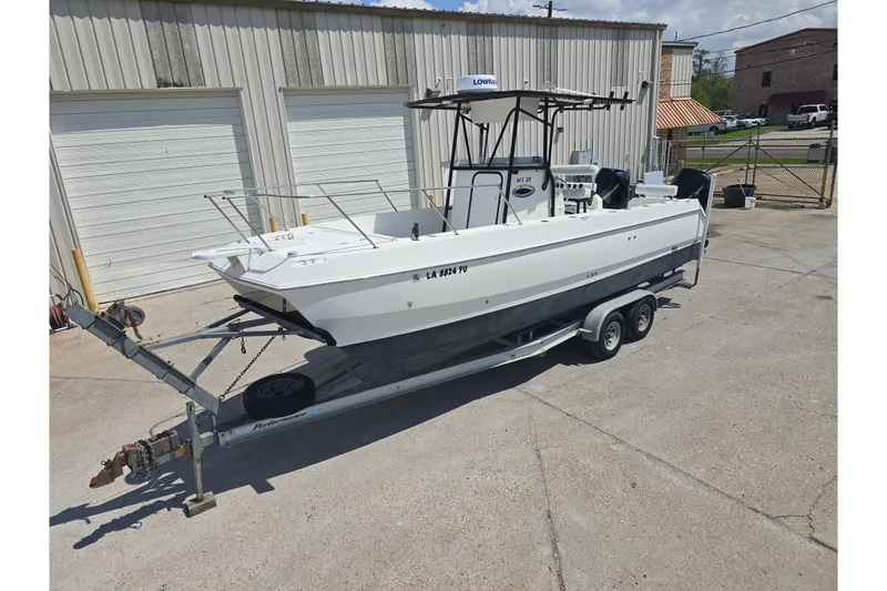Slide: The Image of 2002 Sport-Craft Seacat 255 boat on trailer, parked outside a garage. - 25
