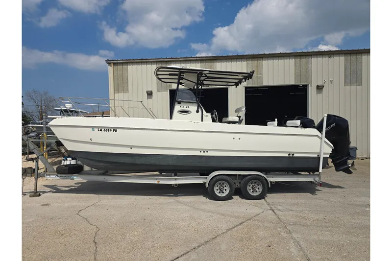 Slide: The Image of 2002 Sport-Craft Seacat 255 boat on trailer, parked outside a warehouse. - 3