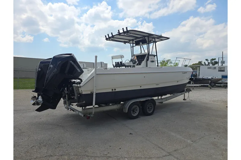Slide: The Image of 2002 Sport-Craft Seacat 255 boat on trailer, dual outboard motors, under cloudy sky. - 6